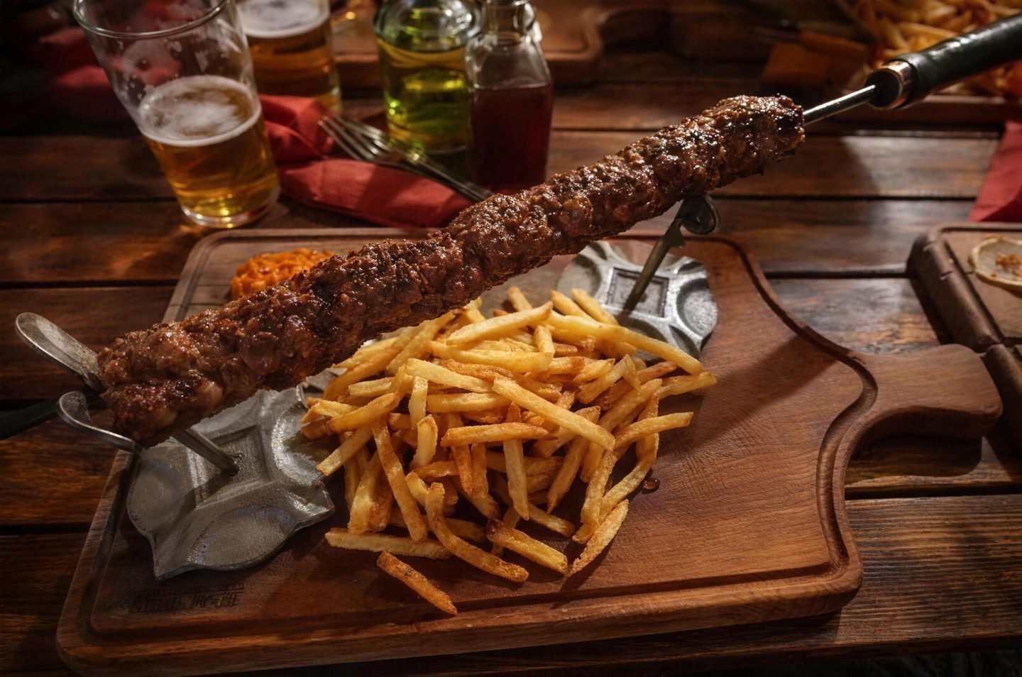 Šiš ćevap na ražnju s pomfritom na drvenoj dasci